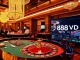 Place your bets at the exclusive 888VND VIP casino, featuring a vibrant roulette table and engaging players.